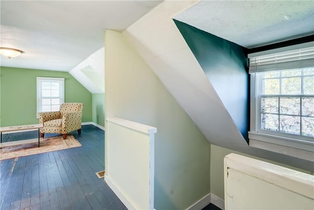 bonus room with baseboards, lofted ceiling, and dark wood-style floors