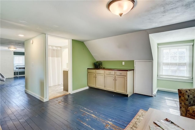 bonus room with baseboards, dark wood-style floors, and lofted ceiling