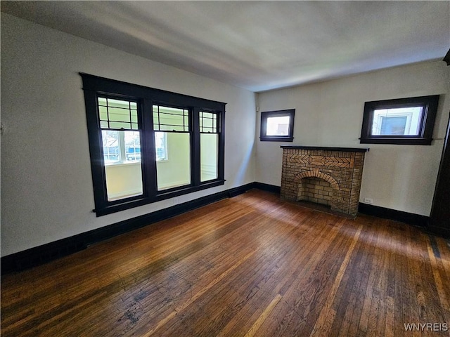 unfurnished living room featuring wood-type flooring, baseboards, and a fireplace