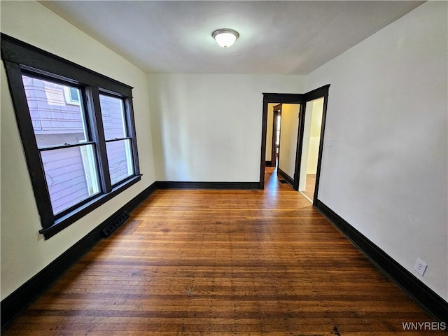 empty room featuring baseboards and wood finished floors