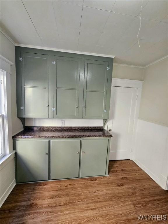 interior space featuring crown molding, baseboards, and wood finished floors