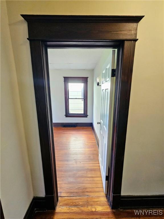 hallway featuring baseboards and wood finished floors