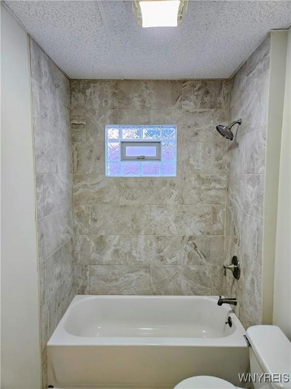 bathroom with shower / bathing tub combination and toilet