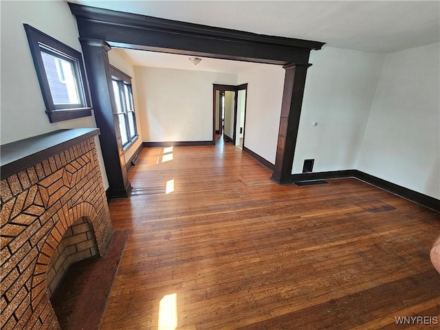 spare room featuring baseboards and dark wood-style floors