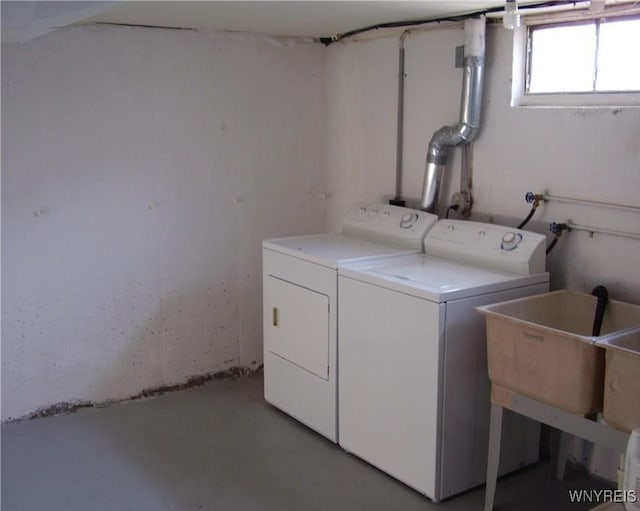 washroom with a sink, laundry area, and washer and clothes dryer