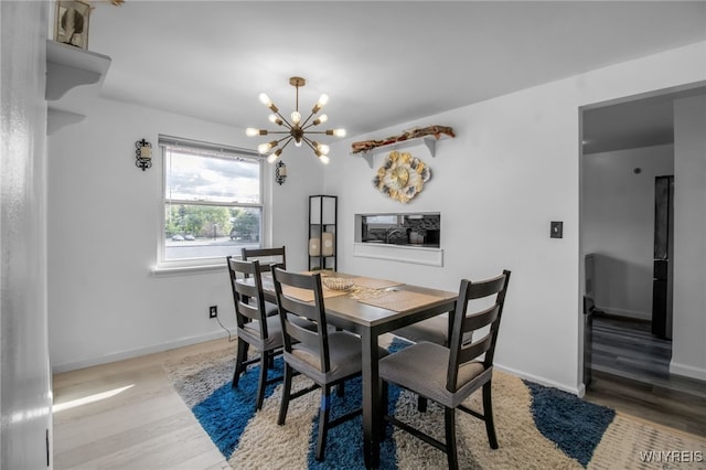 dining space featuring an inviting chandelier, light wood-style flooring, and baseboards
