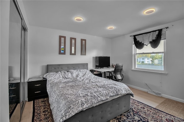 bedroom featuring light wood-style floors, recessed lighting, baseboards, visible vents, and a closet