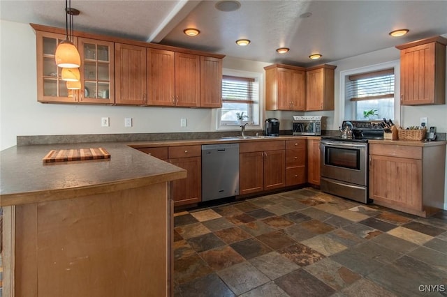21959 County Route 59, Brownville, NY 13634 - kitchen featuring brown cabinetry, dark countertops, stone tile flooring, glass insert cabinets, and stainless steel appliances