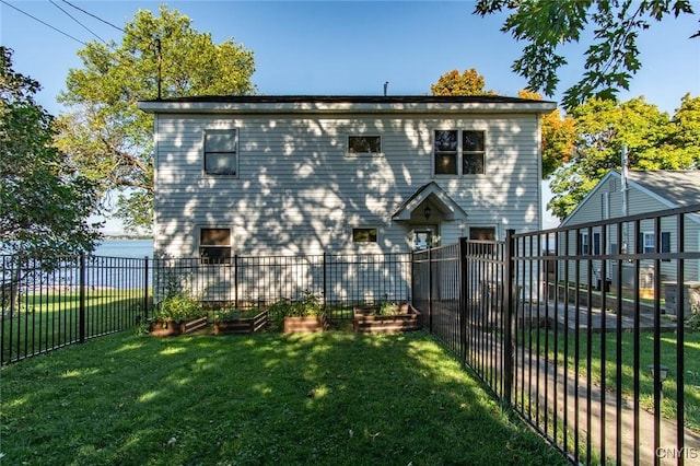 21959 County Route 59, Brownville, NY 13634 - back of house with a lawn, a water view, fence, and a vegetable garden