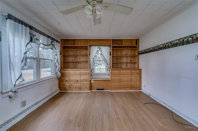empty room with wood finished floors, baseboards, ceiling fan, a baseboard heating unit, and built in shelves