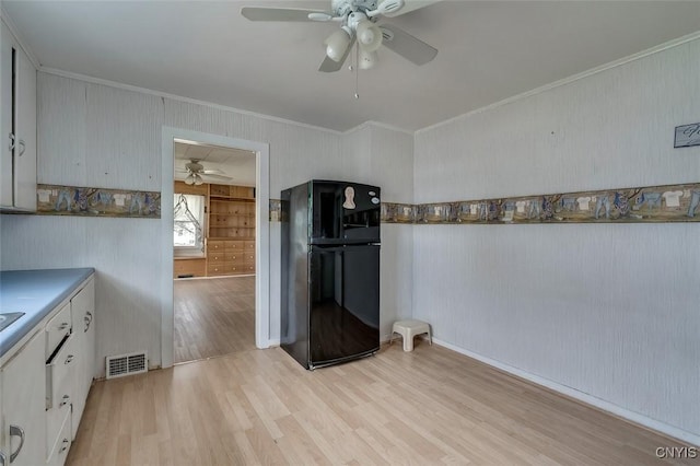kitchen with visible vents, freestanding refrigerator, ornamental molding, light wood-style floors, and ceiling fan