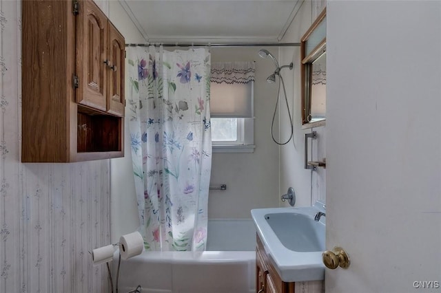 bathroom featuring a sink, shower / bath combination with curtain, and ornamental molding