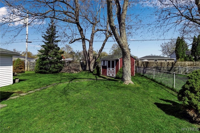 view of yard featuring a storage shed, an outdoor structure, and a fenced backyard