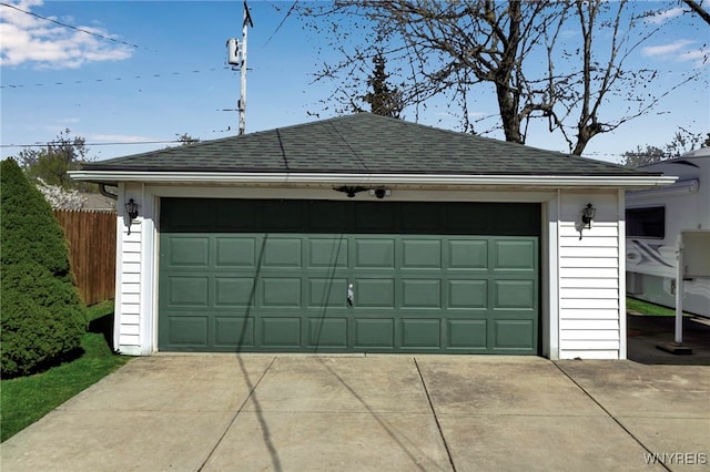 detached garage featuring fence