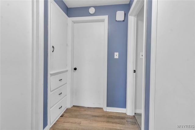 hall featuring baseboards and wood finished floors
