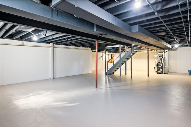 basement with heating unit and stairway