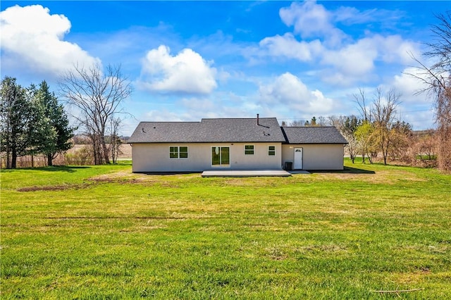 back of house with a patio area, stucco siding, and a yard