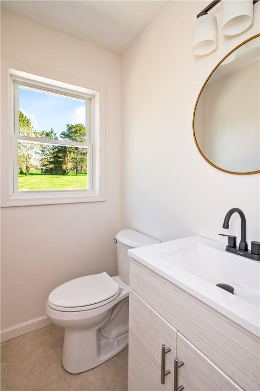 bathroom featuring vanity, tile patterned flooring, and toilet