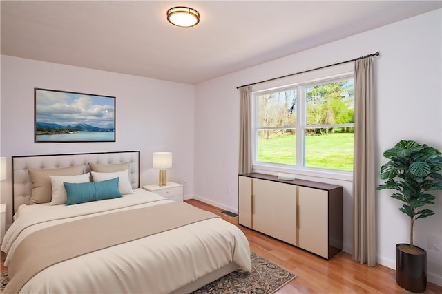 bedroom with light wood-type flooring and baseboards