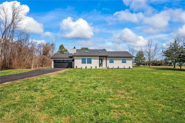 ranch-style home with a garage, stucco siding, a front yard, a chimney, and driveway