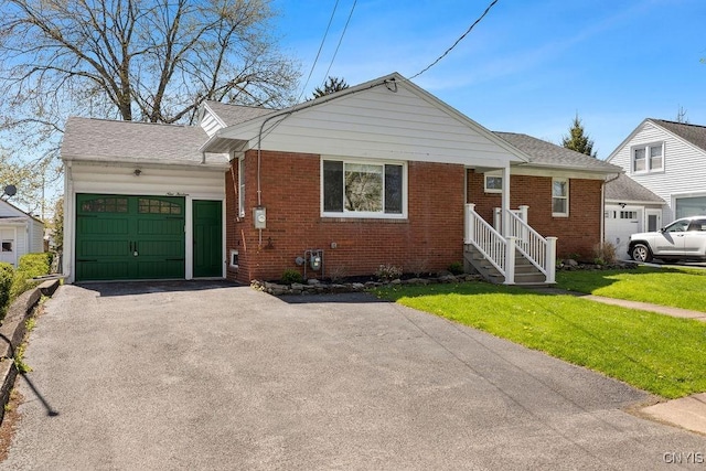 bungalow with an attached garage, a front lawn, aphalt driveway, and brick siding