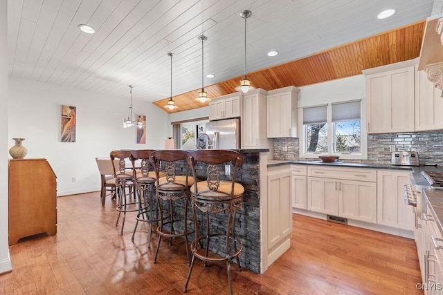 kitchen featuring wooden ceiling, stainless steel fridge with ice dispenser, plenty of natural light, and recessed lighting