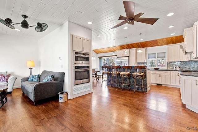 kitchen with wood ceiling, ceiling fan, dark countertops, and stainless steel appliances