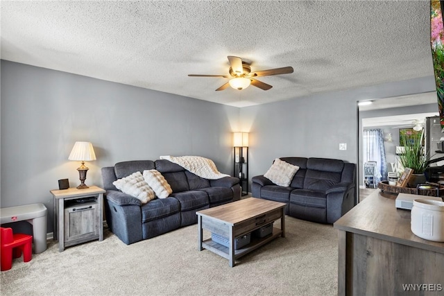 carpeted living area with a textured ceiling and ceiling fan