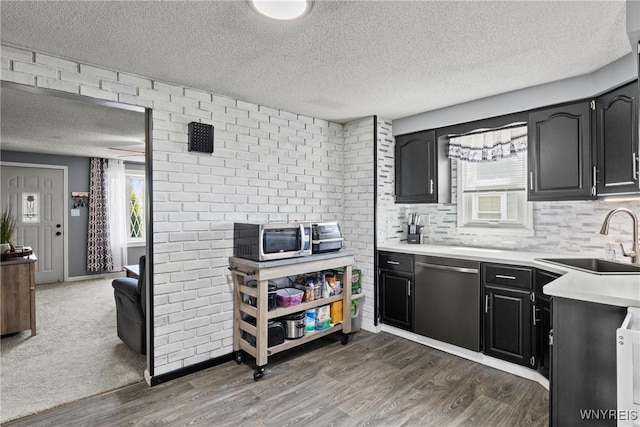 kitchen with stainless steel appliances, a textured ceiling, dark wood-style floors, and a sink