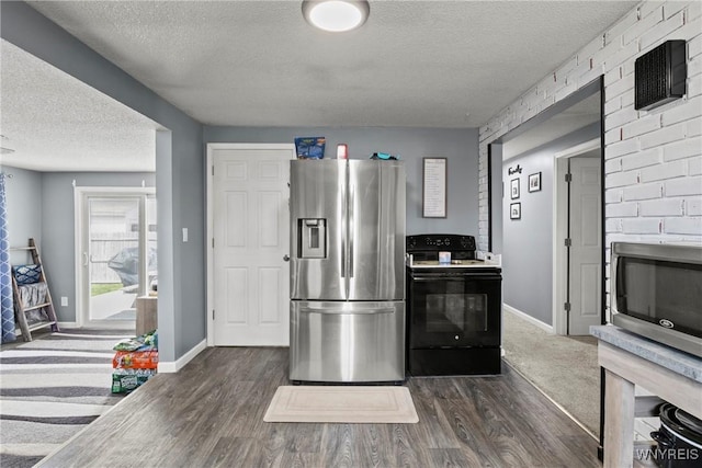 kitchen featuring a textured ceiling, appliances with stainless steel finishes, dark wood-style floors, and baseboards