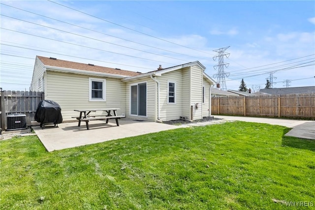 rear view of house with a lawn, fence, and a patio area