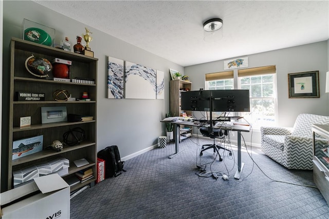 carpeted office featuring baseboards and a textured ceiling