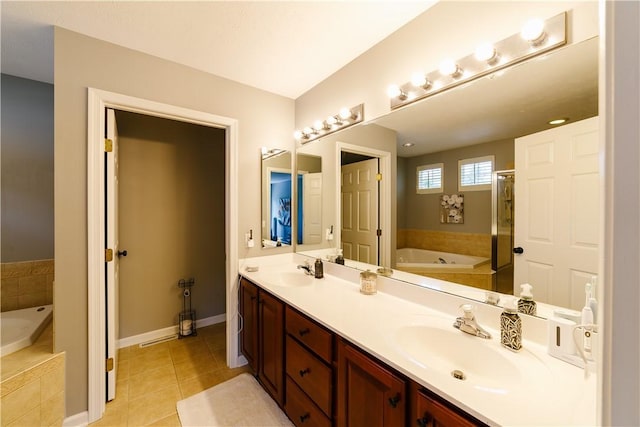bathroom featuring a sink, tile patterned flooring, double vanity, and a bath