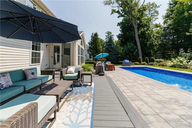pool featuring an outdoor living space and a patio area
