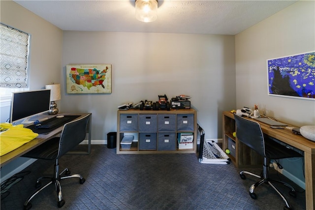 office area with baseboards and dark colored carpet