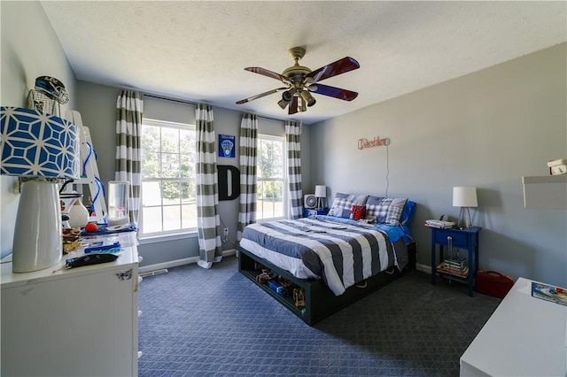 bedroom with baseboards, carpet flooring, a textured ceiling, and a ceiling fan