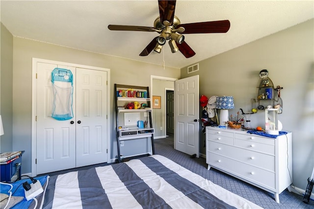 bedroom with a ceiling fan, visible vents, baseboards, a closet, and dark colored carpet