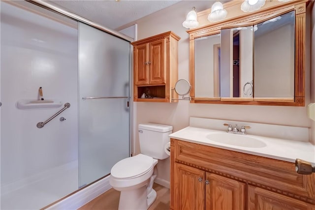full bathroom with vanity, toilet, and a shower stall