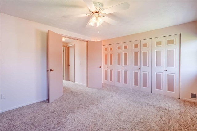 unfurnished bedroom featuring ceiling fan, visible vents, baseboards, a closet, and carpet flooring