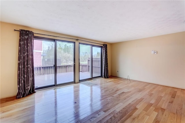 spare room featuring wood finished floors and visible vents