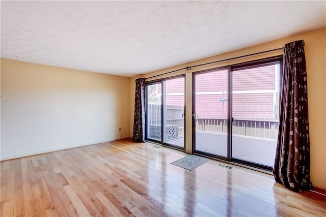 spare room featuring wood finished floors and visible vents