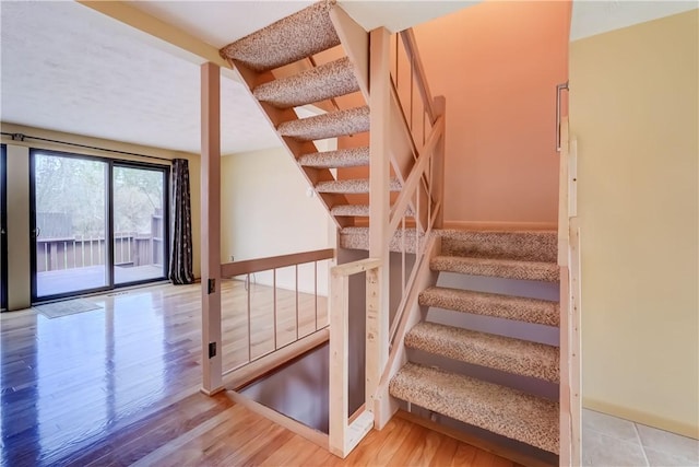 stairway featuring baseboards and wood finished floors