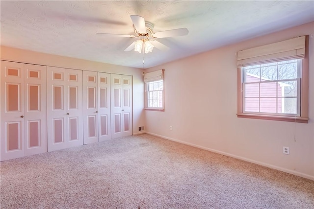 unfurnished bedroom with carpet floors, baseboards, and a closet