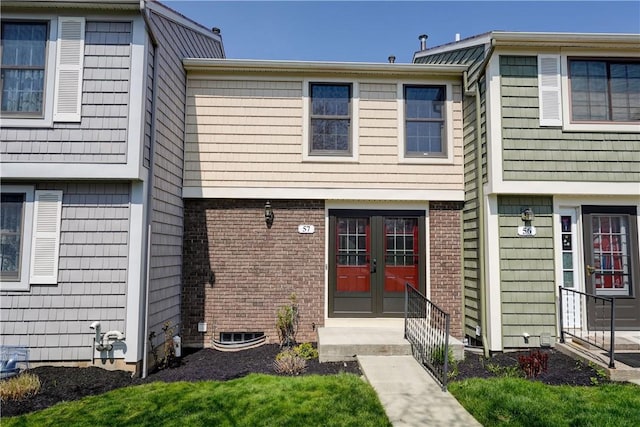 view of front of house featuring brick siding, french doors, and entry steps