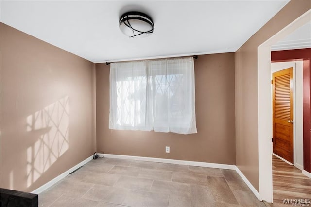unfurnished room with baseboards