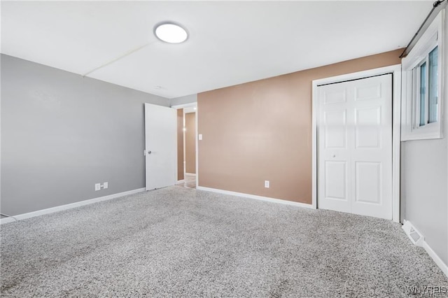unfurnished bedroom featuring a closet, carpet, and baseboards