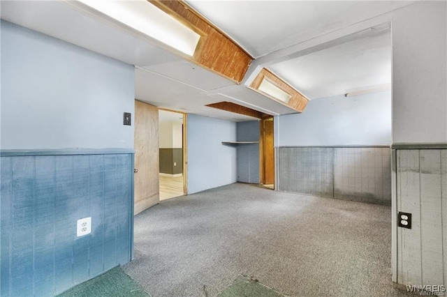 carpeted spare room featuring wainscoting