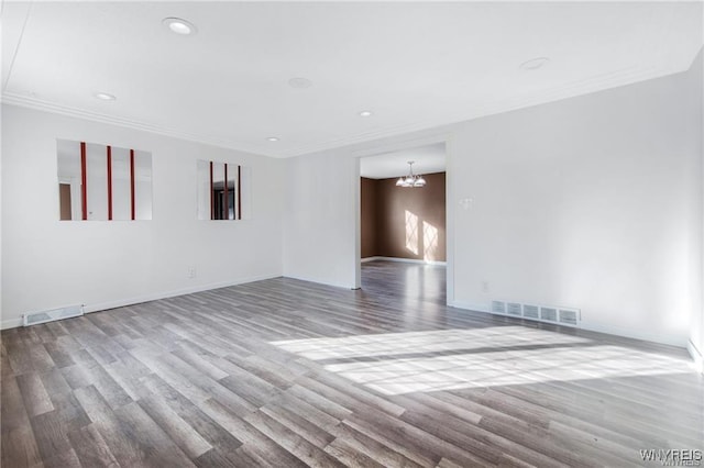 spare room featuring ornamental molding, a notable chandelier, and visible vents