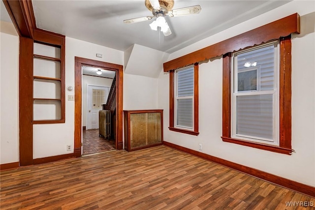 empty room featuring baseboards, ceiling fan, and wood finished floors