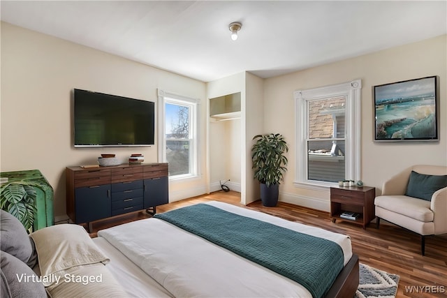 bedroom with baseboards and wood finished floors